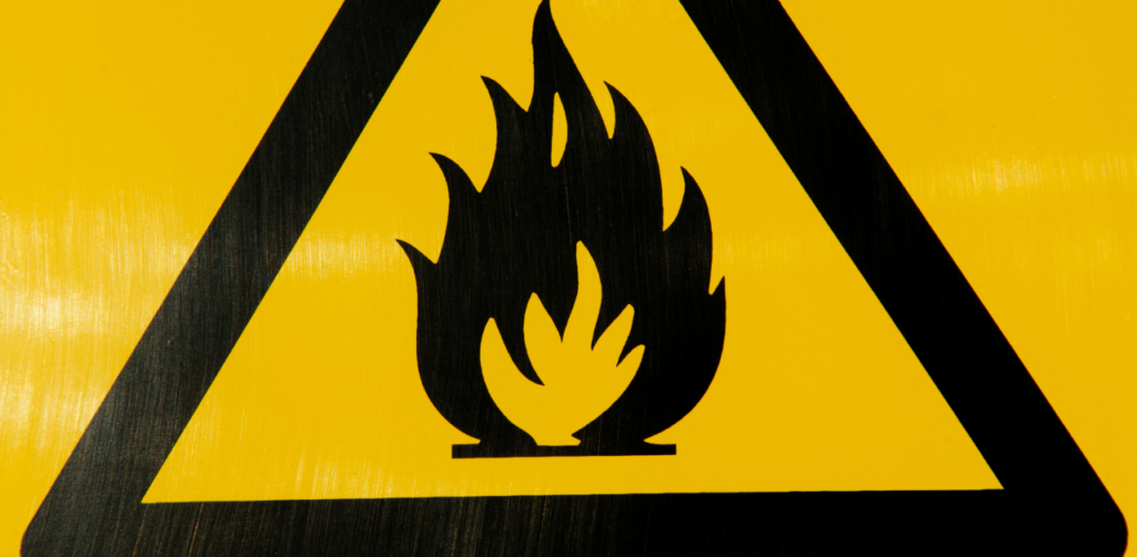 Black flame symbol inside a yellow triangle, indicating a fire hazard warning