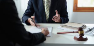 Elder law attorney discusses legal forms with client at desk, gavel and documents visible