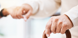 Senior holding a cane receives support, symbolizing elder care and legal assistance