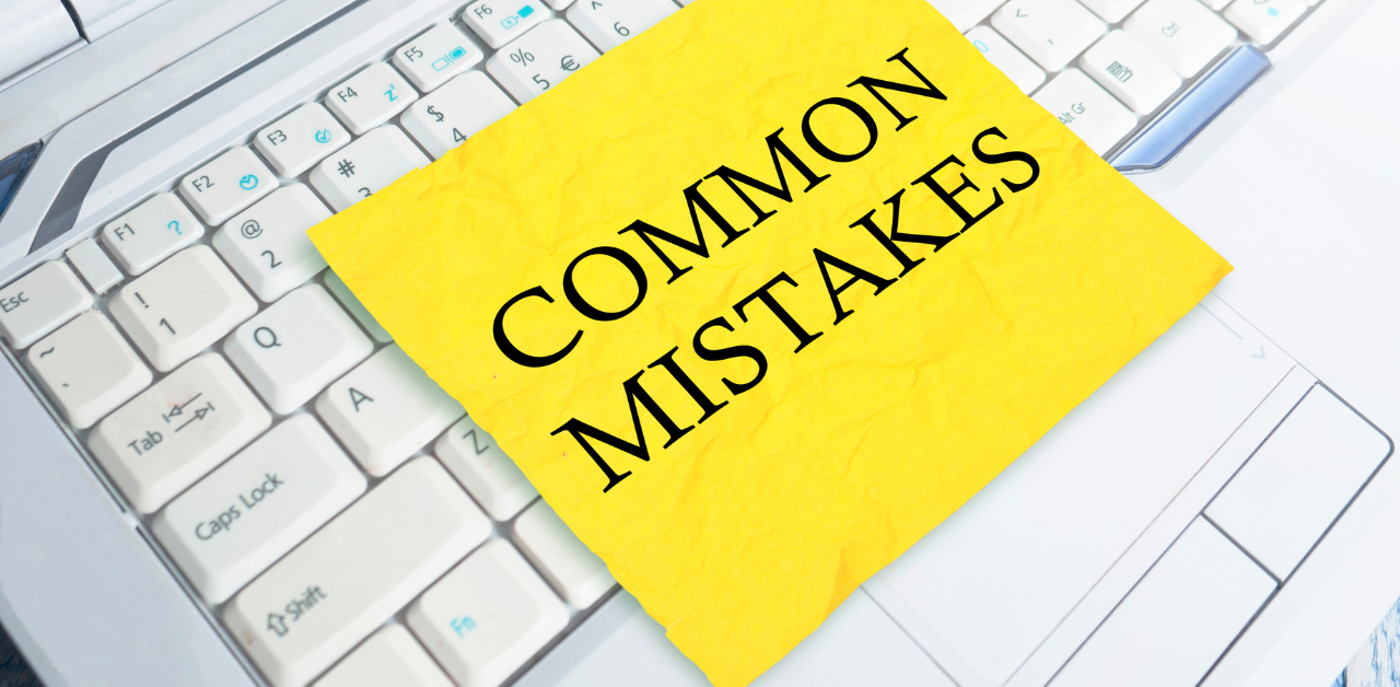 A bright yellow sticky note with the words "Common Mistakes" is placed on a white computer keyboard