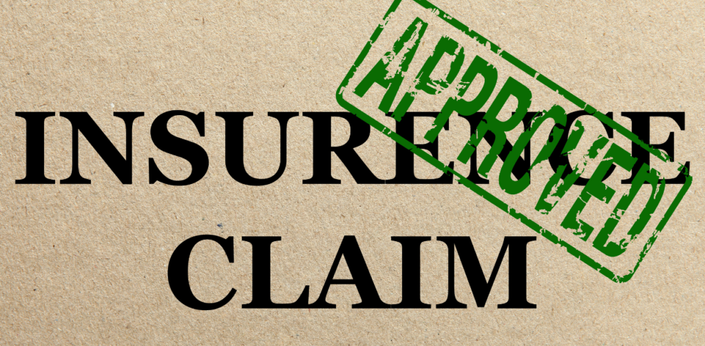 The words INSURANCE CLAIM stamped with a green APPROVED mark on textured paper