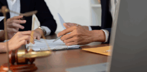 Lawyers review documents around a table, with a gavel and legal scale symbolizing a personal injury case