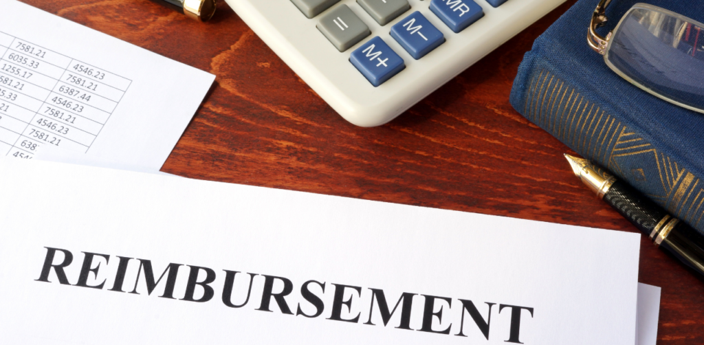 A reimbursement document on a desk with a calculator, pen, and a financial ledger