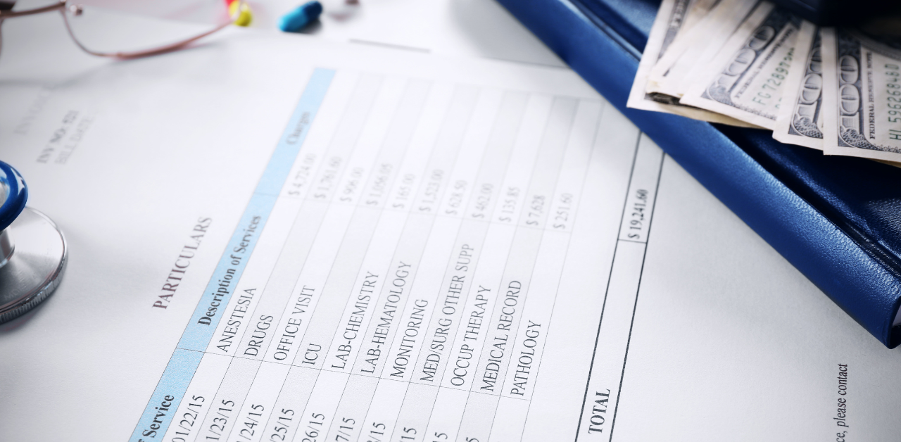 A hospital bill with itemized charges lies next to cash in a wallet, suggesting high medical expenses