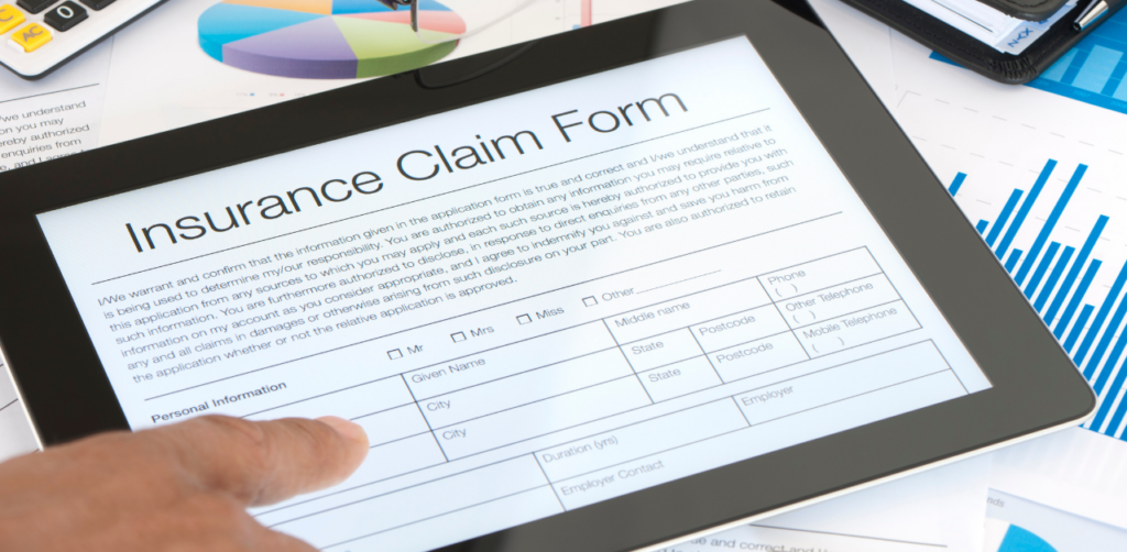 Finger pointing to a section on a digital insurance claim form displayed on a tablet