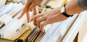 Attorney organizing client case files in filing cabinet