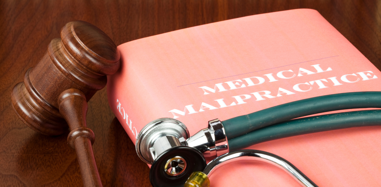 Medical malpractice file with gavel and stethoscope on desk