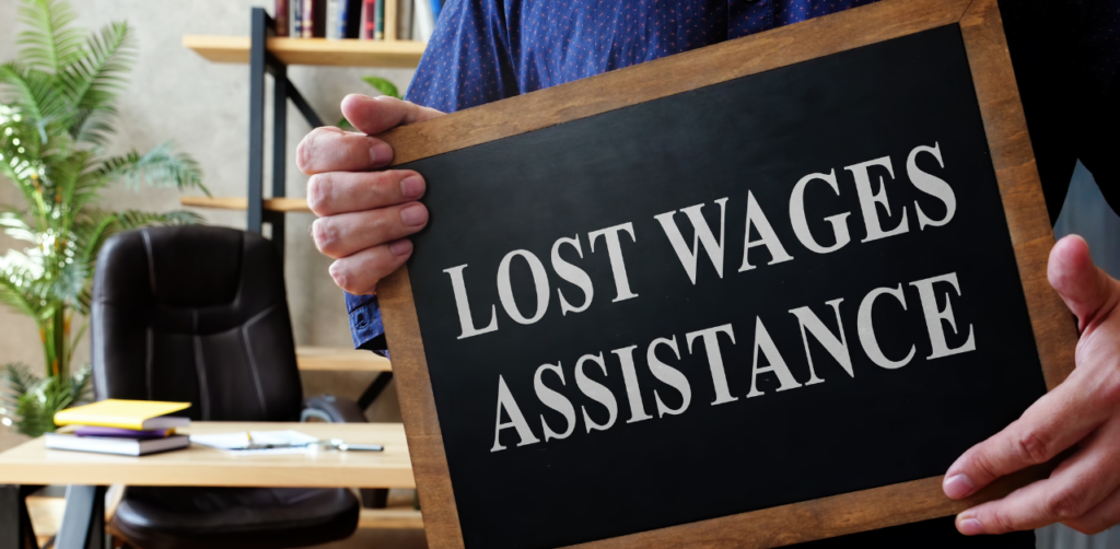 Person holding a chalkboard sign with the text "Lost Wages Assistance" in an office setting