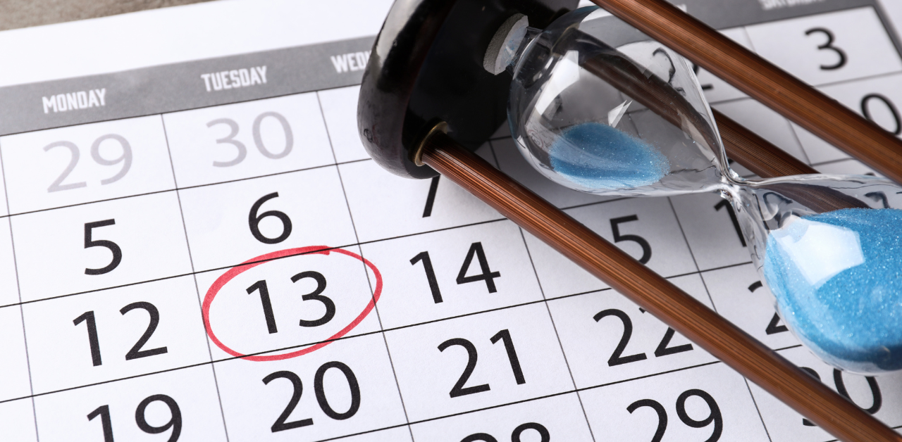 A calendar with the number 13 circled in red, alongside an hourglass filled with blue sand