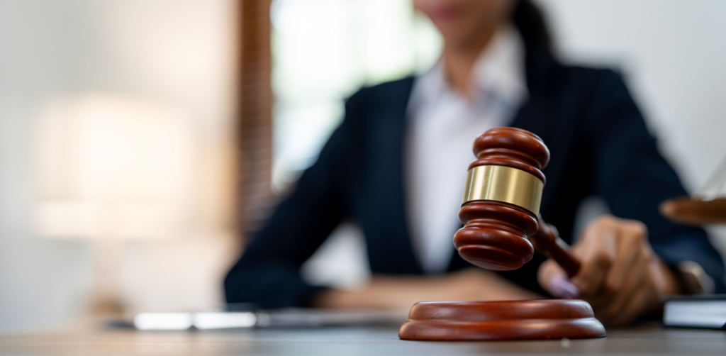 A judge holding a wooden gavel in a courtroom, preparing to make a ruling