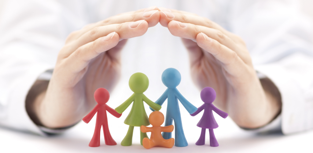 Two hands cupping over colorful paper cutouts of a family, symbolizing protection or insurance