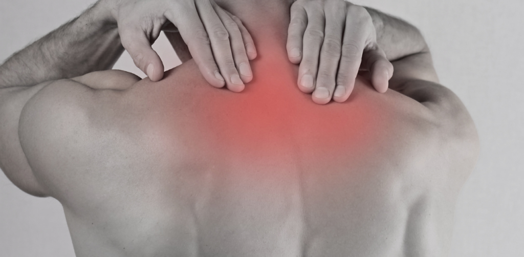 Person holding their upper back with both hands, with a red overlay highlighting pain