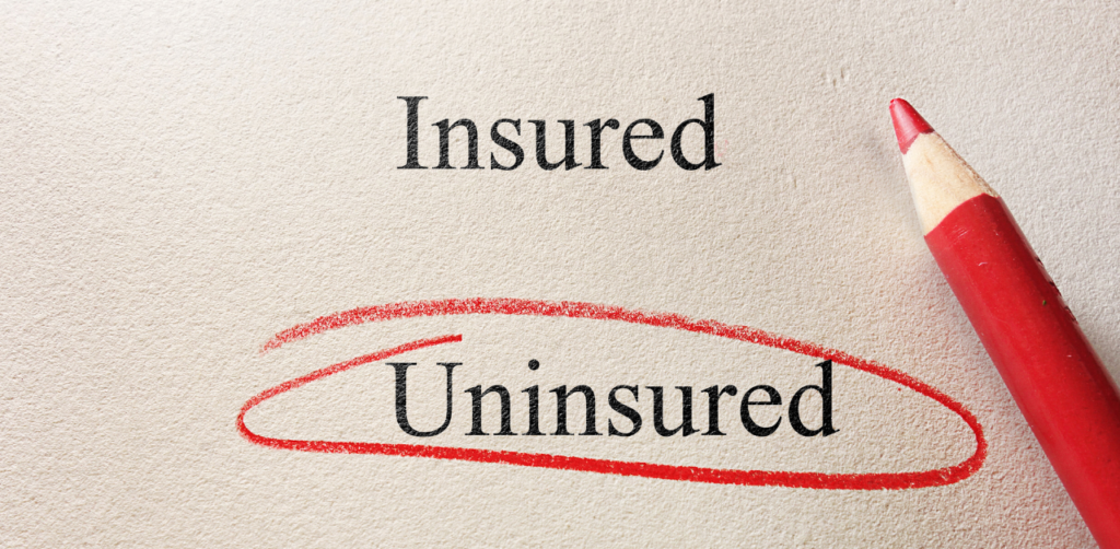 The words Insured and Uninsured, with Uninsured circled in red pencil on a beige background
