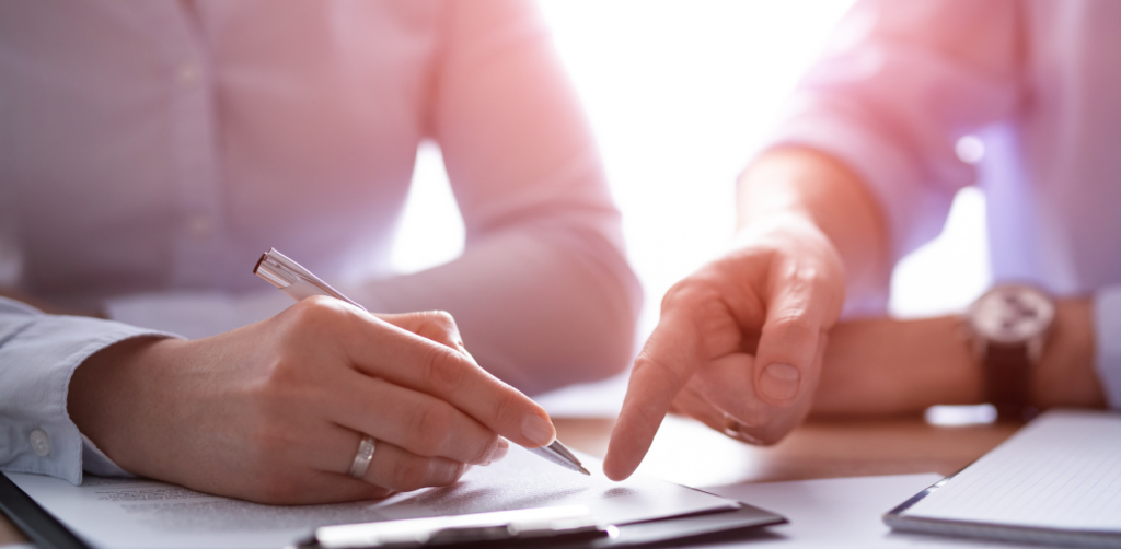 Close-up of two professionals reviewing and signing paperwork, symbolizing legal settlements and insurance claims for car accidents in Las Vegas