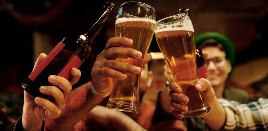 Friends toasting with beer glasses and bottles in a festive pub setting