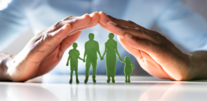 Hands form a protective gesture over a green family cutout, symbolizing insurance coverage and financial security