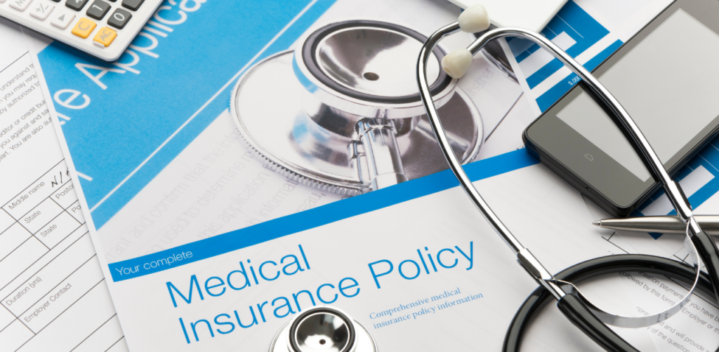 Medical insurance policy document with a stethoscope and calculator