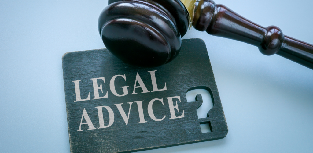 Wooden gavel resting on a Legal Advice sign, symbolizing legal consultation and guidance