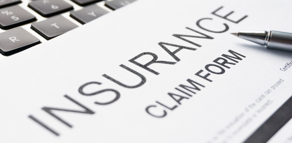 Close-up of an insurance claim form on a laptop with a pen, highlighting insurance paperwork and processing