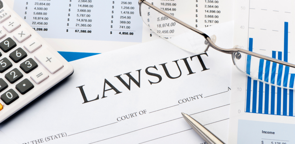 Lawsuit form with charts, calculator, and glasses, showing financial prep for a legal settlement