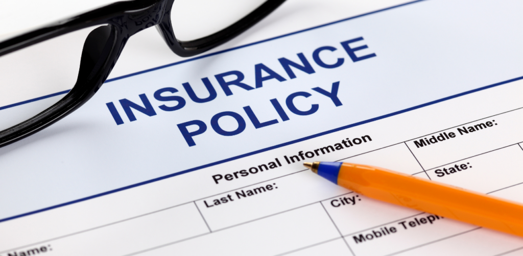 Close-up of an insurance policy form with a pen and eyeglasses, ready for personal information entry