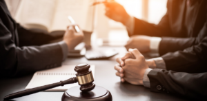 Lawyers in suits at meeting table with gavel, discussing legal strategy or preparing for a lawsuit