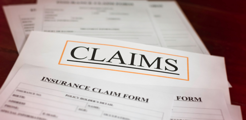Close-up of insurance claim forms with “CLAIMS” boldly printed on top, ready to be filled out