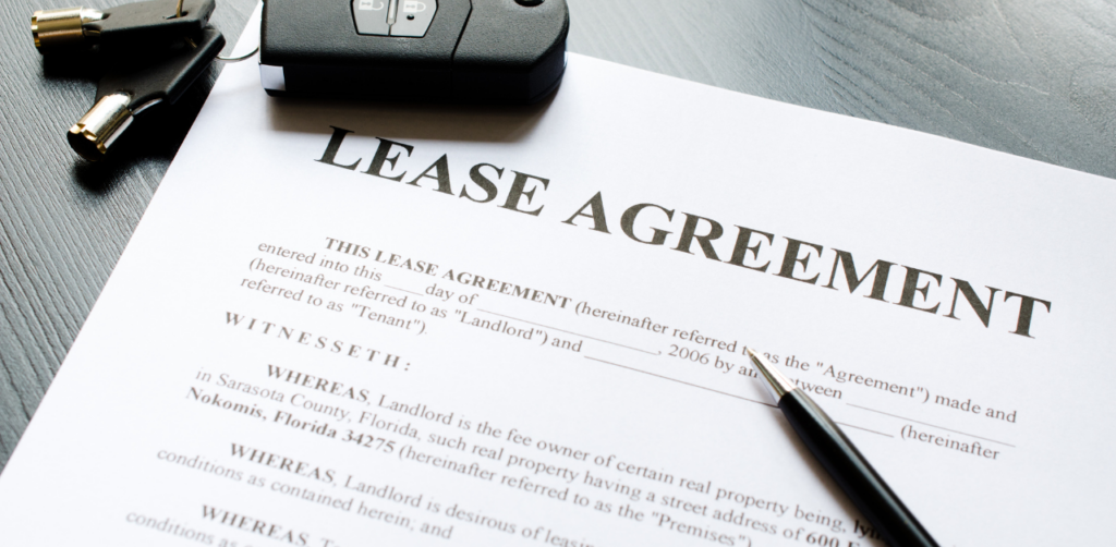 Lease agreement document with pen and car keys, representing a signed auto lease contract