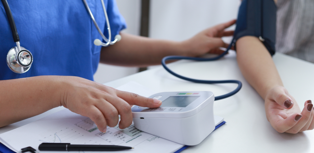 Nurse checks a patient's blood pressure using a digital monitor in a clinical setting