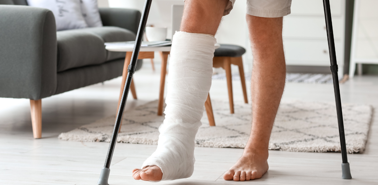Person with a bandaged leg uses crutches to walk at home after a foot injury