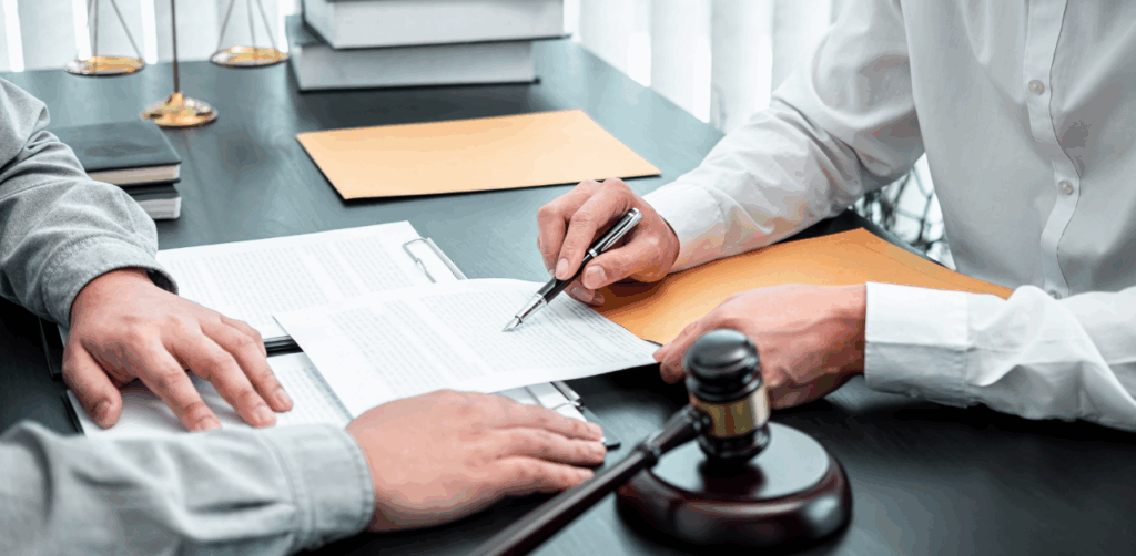 A legal advisor explains contract terms to a client, with a gavel and documents on the table