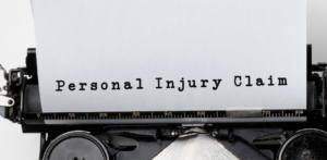 Close-up of a vintage typewriter typing the words “Personal Injury Claim” on white paper