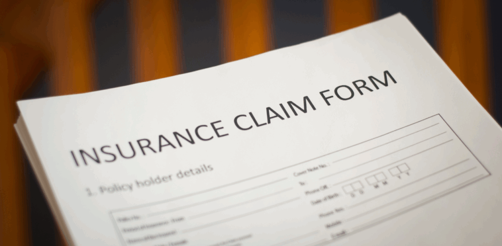 Close-up of a blank “Insurance Claim Form” on a wooden surface, ready to be filled out for a personal injury or accident-related insurance request