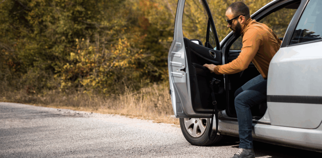 Man opens car door on roadside, posing potential risk for a cyclist dooring accident