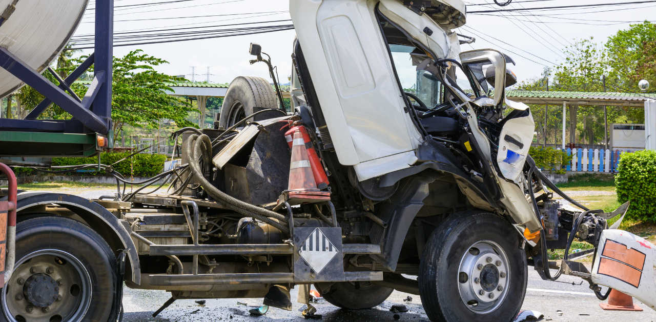 Front of white truck crushed in a collision, damage under review for truck accident investigation
