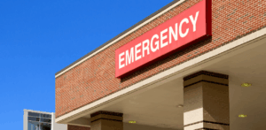 Hospital building with large red EMERGENCY sign on brick exterior