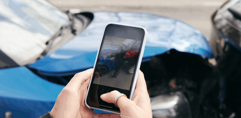 Person takes a photo of a car crash using a smartphone for documentation