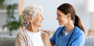 Smiling nurse supports elderly woman at home, reflecting caring elderly home care service