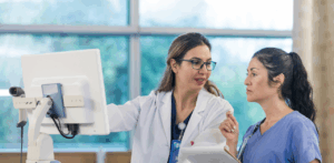 Doctor and nurse reviewing patient data on a computer in a hospital