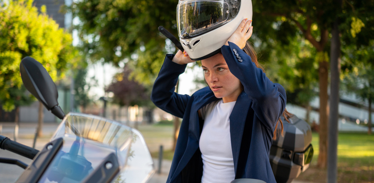Woman putting on motorcycle helmet before riding