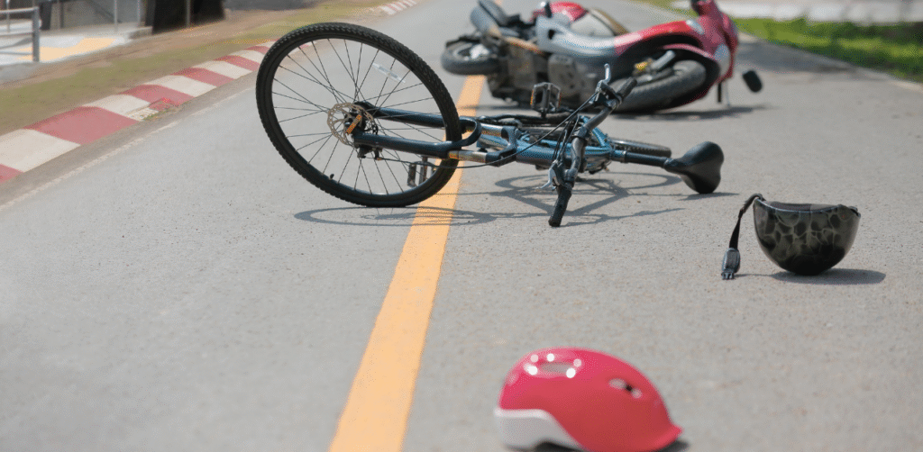 Bicycle accident scene with fallen bike and helmet on roadway