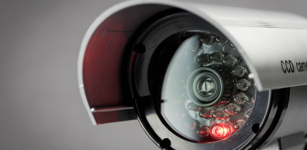 Close-up of a security surveillance camera with red indicator light, ensuring property safety