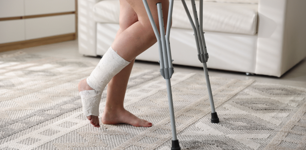 Person using crutches with a bandaged ankle at home during injury recovery
