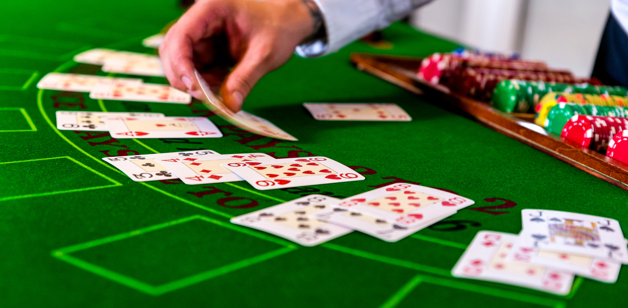 Dealer placing cards on casino table with chips, showing blackjack gameplay and gambling activity