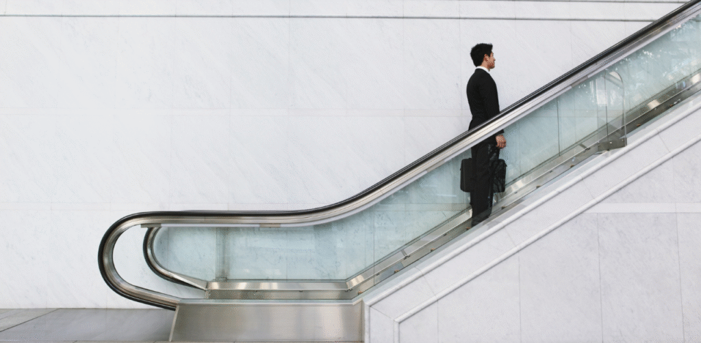 Businessman riding escalator in office, symbolizing Casino Escalator Accident Claims and workplace injury risks