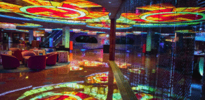Colorful casino interior with neon ceiling lights, lounge seating, and glossy floors, showcasing luxury nightlife ambiance