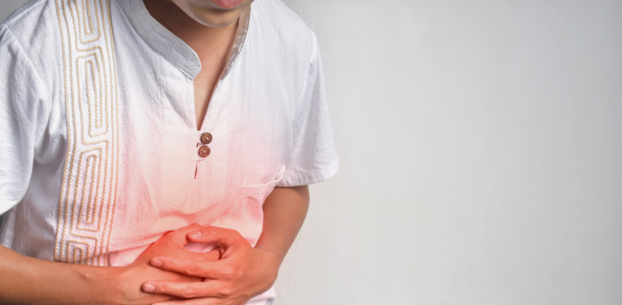 Person clutching abdomen in pain with highlighted stomach area, illustrating abdominal pain or digestive health issue