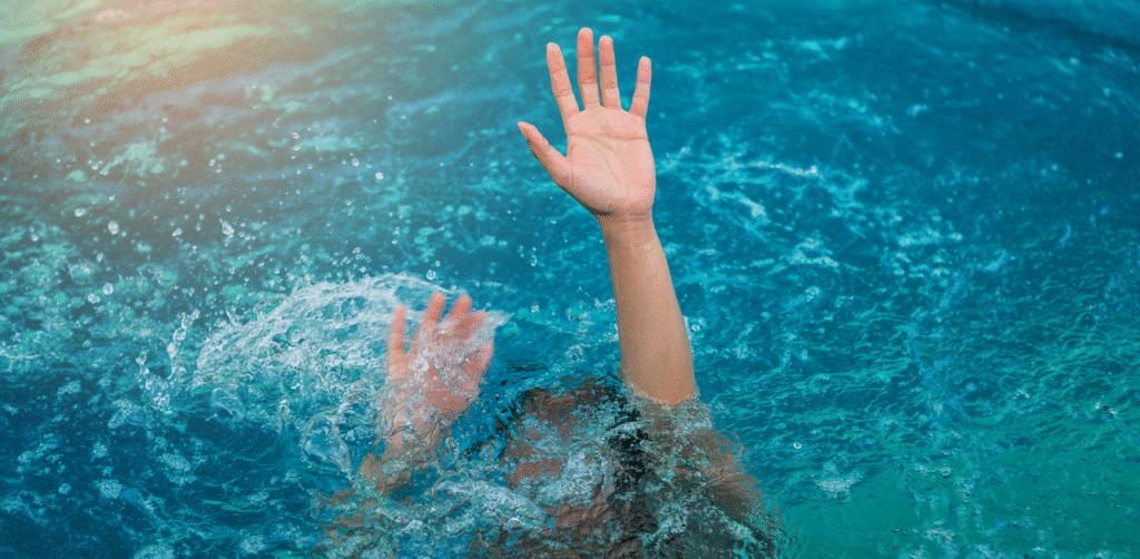Person struggling in water with hand raised, depicting drowning emergency and urgent need for rescue
