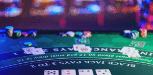 Blackjack table with playing cards and casino chips under colorful lights in a casino setting