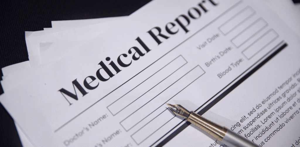Medical report documents stacked with a fountain pen on the page